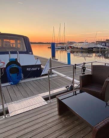 Ferienzentrum Yachthafen Rechlin Müritz Hausboot Villa Hafenblick Terrasse mit Hafen-Blick auf das Nachbarboot