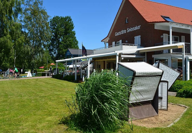 Ferienzentrum Yachthafen Rechlin Müritz Außenansicht der Gaststätte Spinnaker mit Strandkörben und Terrasse