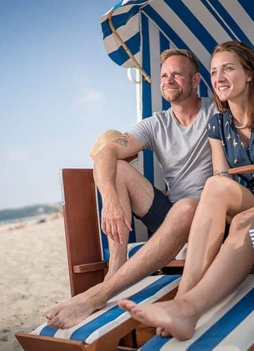 Rügener Ferienhäuser Paar am Strand im Strandkorb