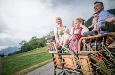 Familie in Tracht bei der Kutschfahrt