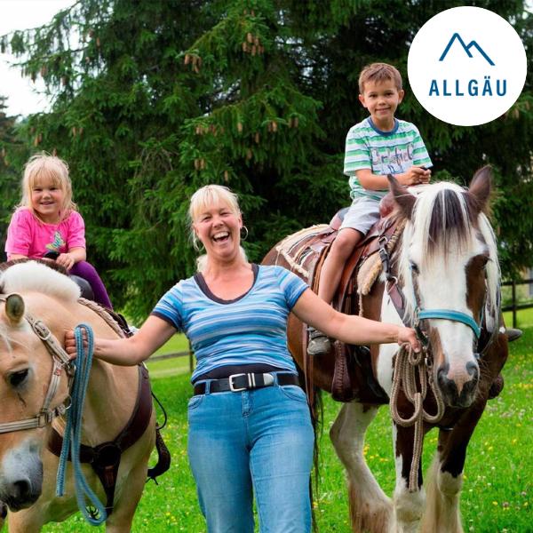Zwei Kinder sitzen auf einem Pferd